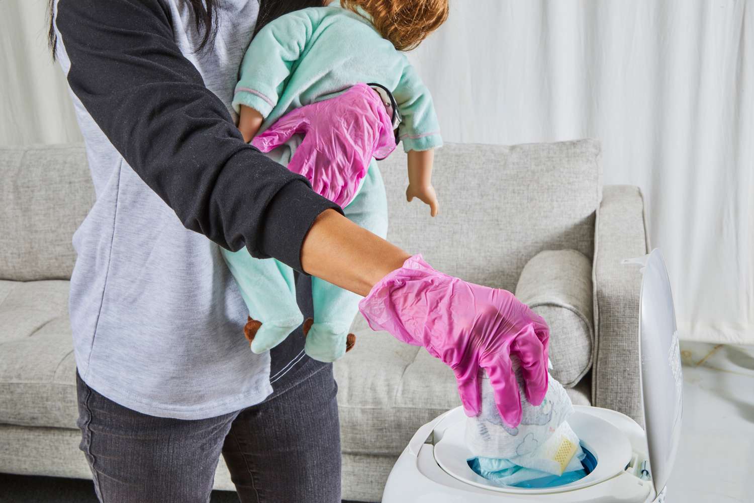 A diaper is placed inside of a Diaper Genie Expressions Diaper Pail