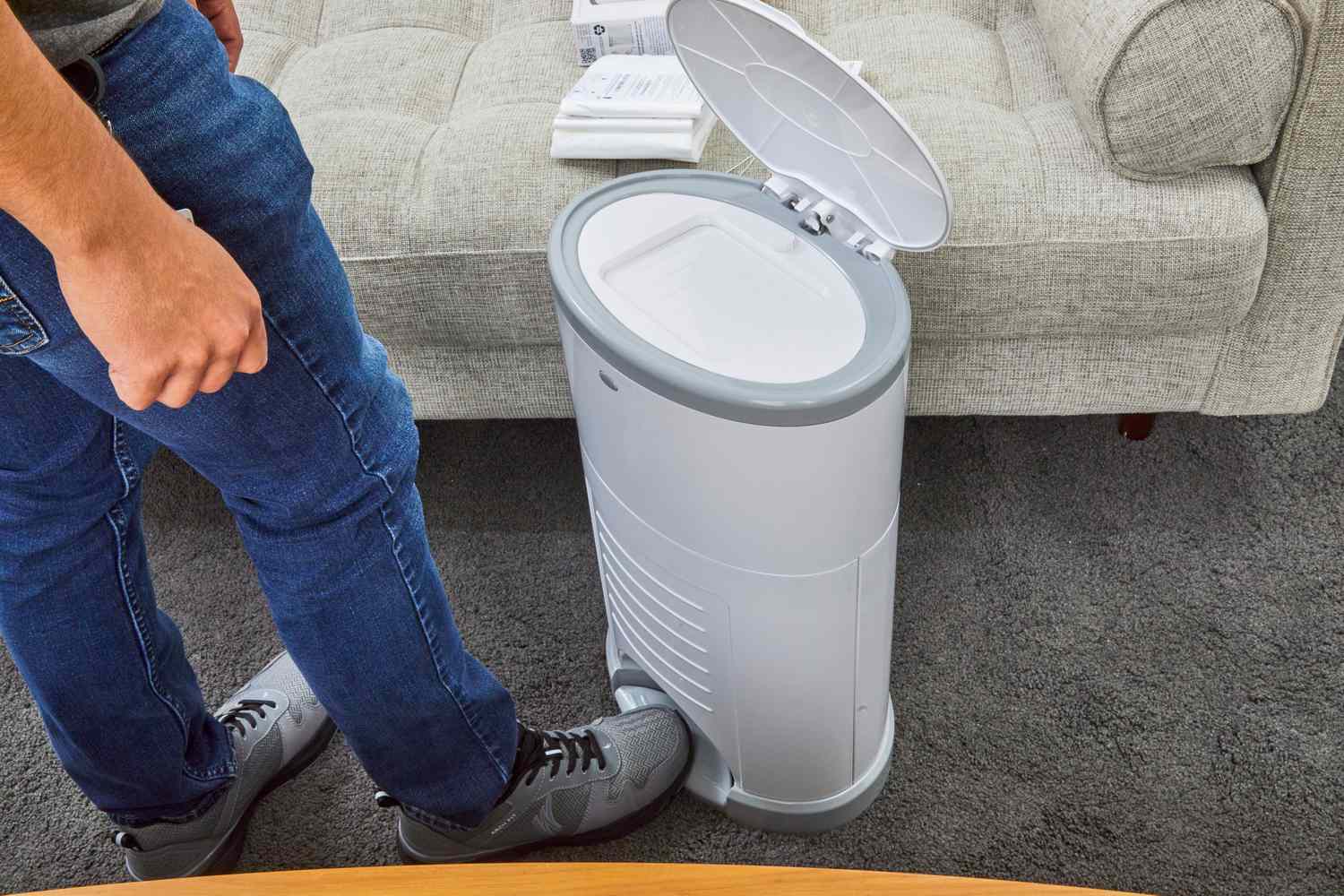 A person steps on the Dekor Classic Hands-Free Diaper Pail